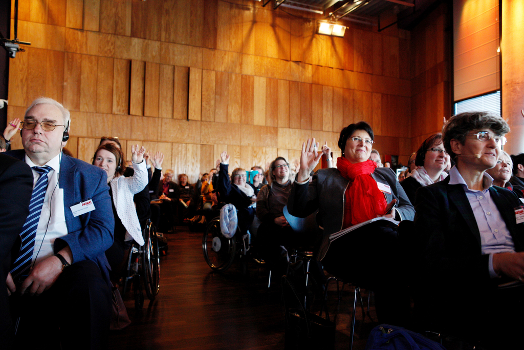 Ein Auszug aus dem Publikum. Einige Teilnehmer heben die Hand