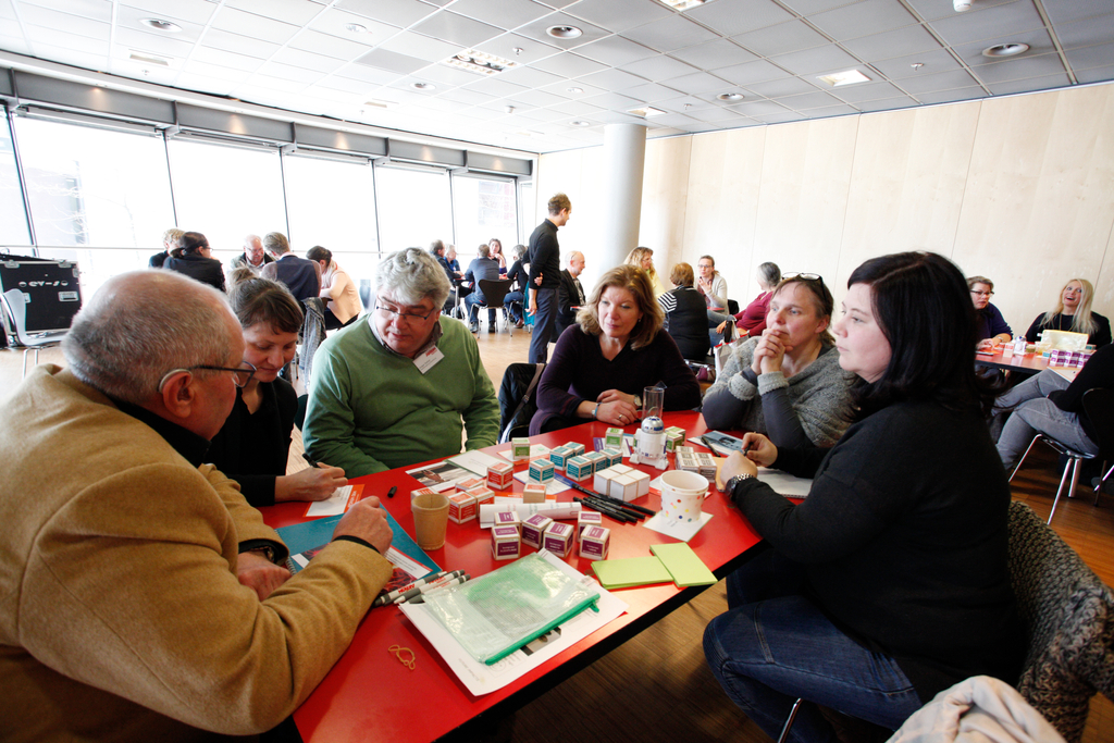 Mehrere Personen sitzen an einem Tisch und reden.