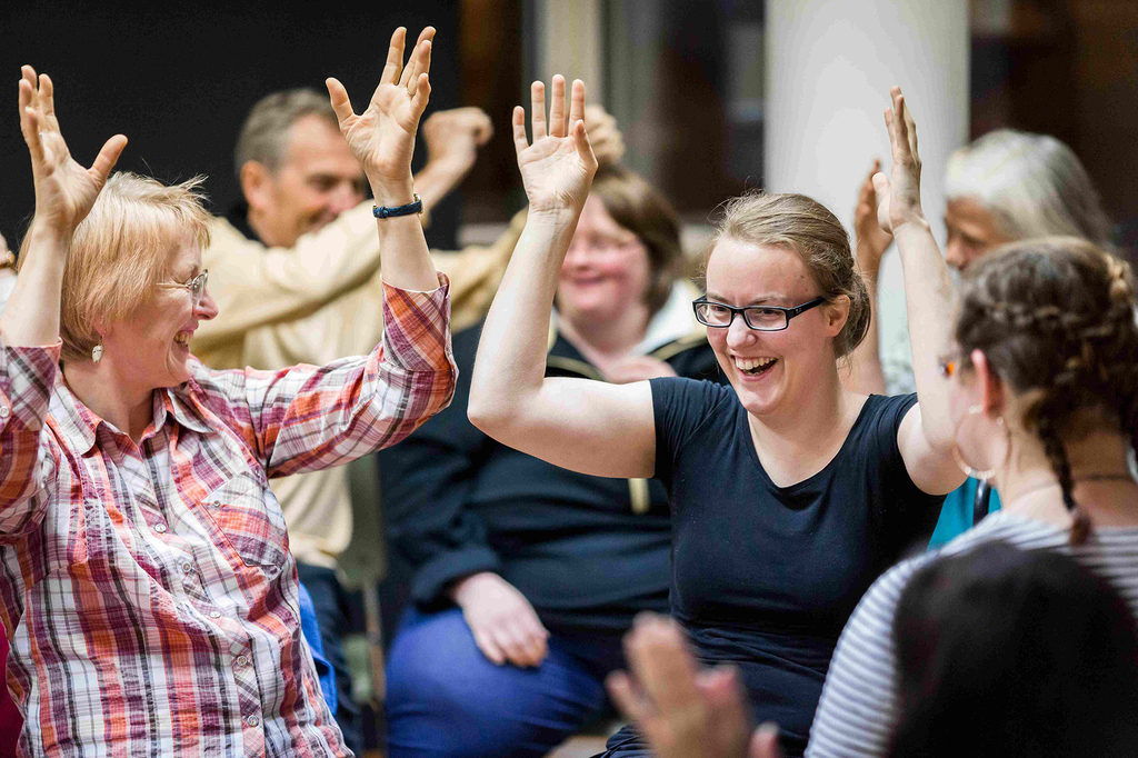 Frauen und Männer gebärden einen Liedtext.