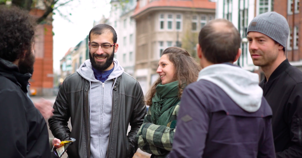 Mehrere Personen, die in einer Gruppe zusammenstehen und lachen.