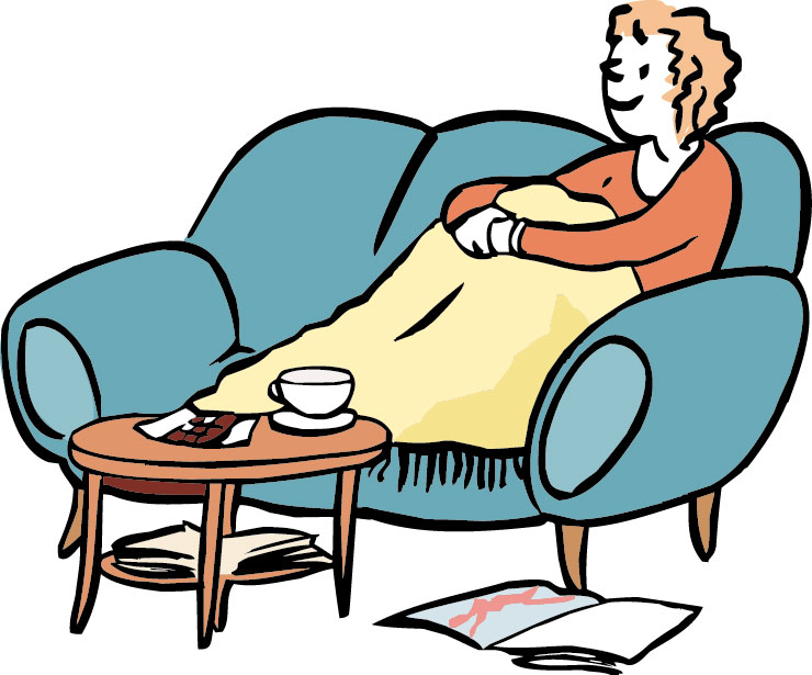 Frau mit Decke sitzt gemütlich auf dem Sofa