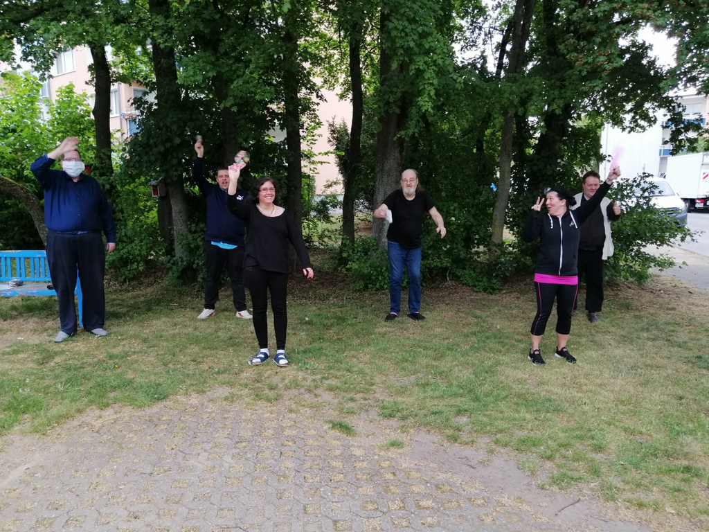 Eine Gruppe von Menschen mit und ohne Behinderung in einem Park.