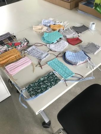Auf einem Tisch ausgebreitet liegen selbstgenähte Masken der AWO in Hilden.