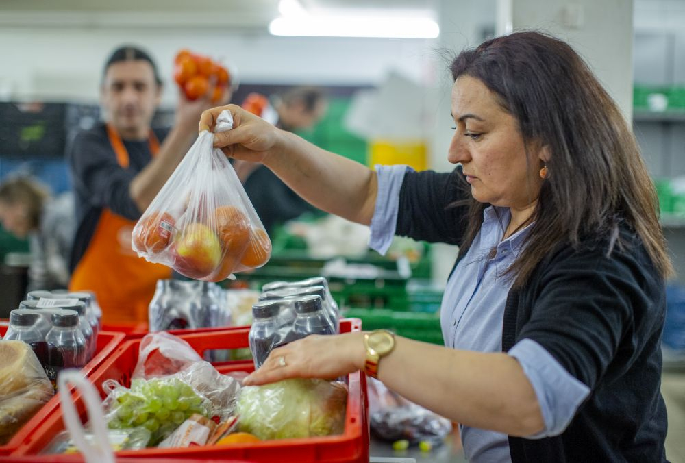 Eine Frau packt Obst ein.