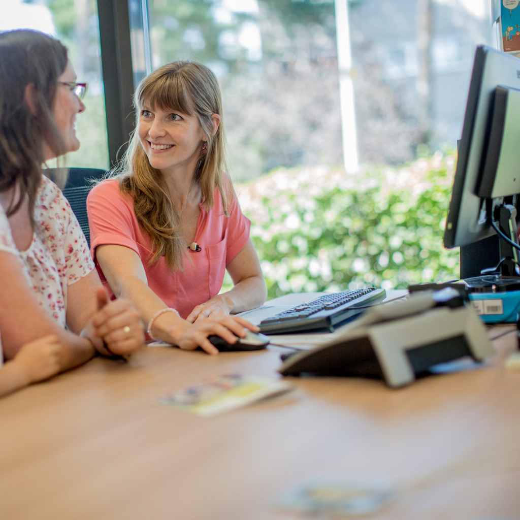 Zwei Frauen sitzen gemeinsam am Computer.