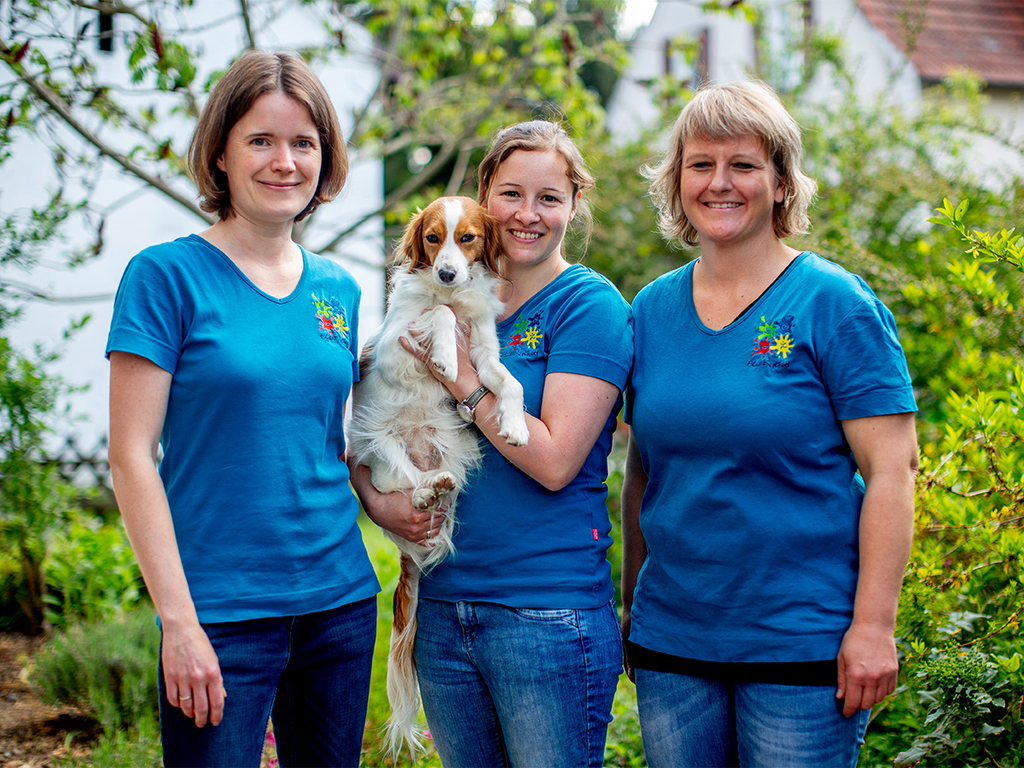 Gruppenfoto vom Team. Drei Frauen und der Therapiehund.