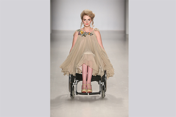 Eine junge Frau im Rollstuhl auf einem Laufsteg.