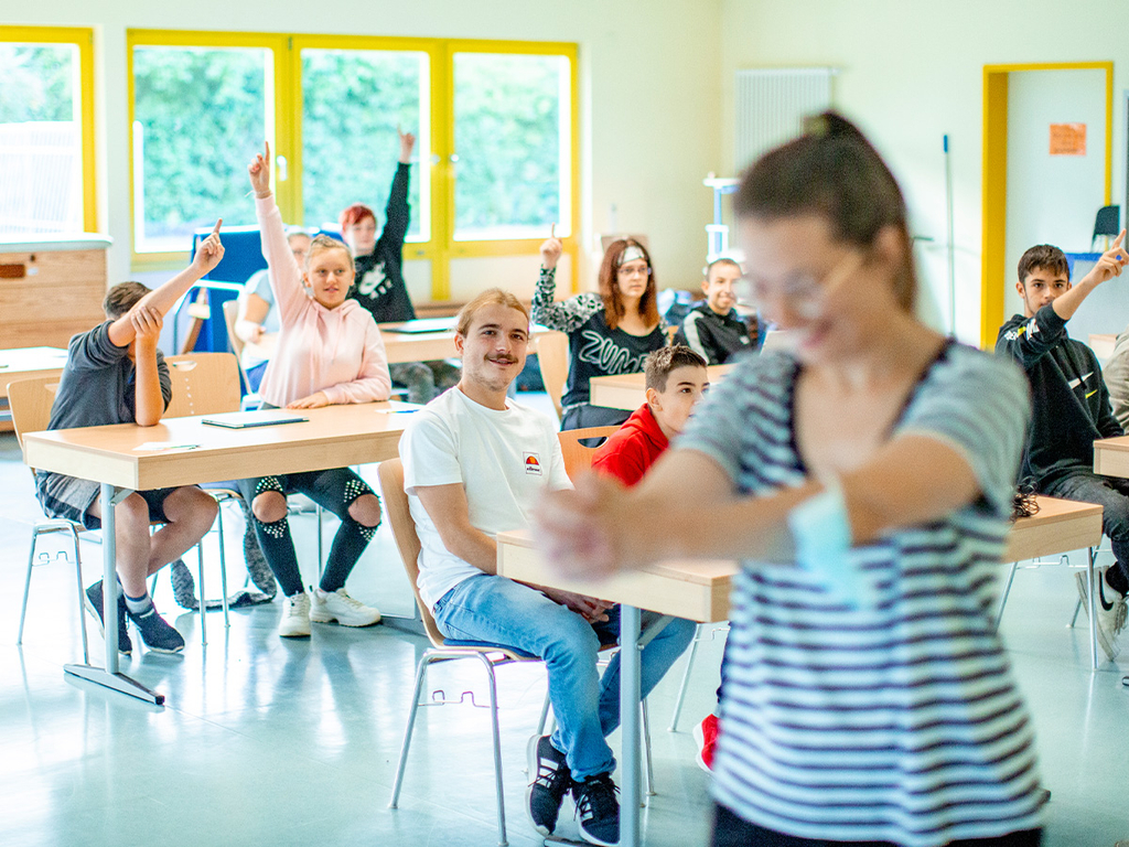 Eine Schülerin führt etwas vor der Klasse vor.