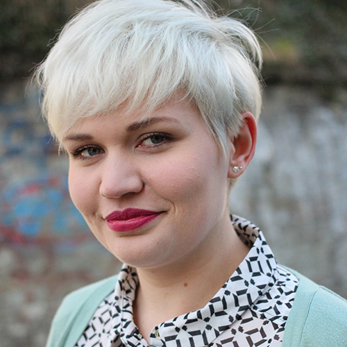 Porträtfoto von Lotte mit kurzen wasserstoffblond gefärbten Haaren und knallrotem Lippenstift