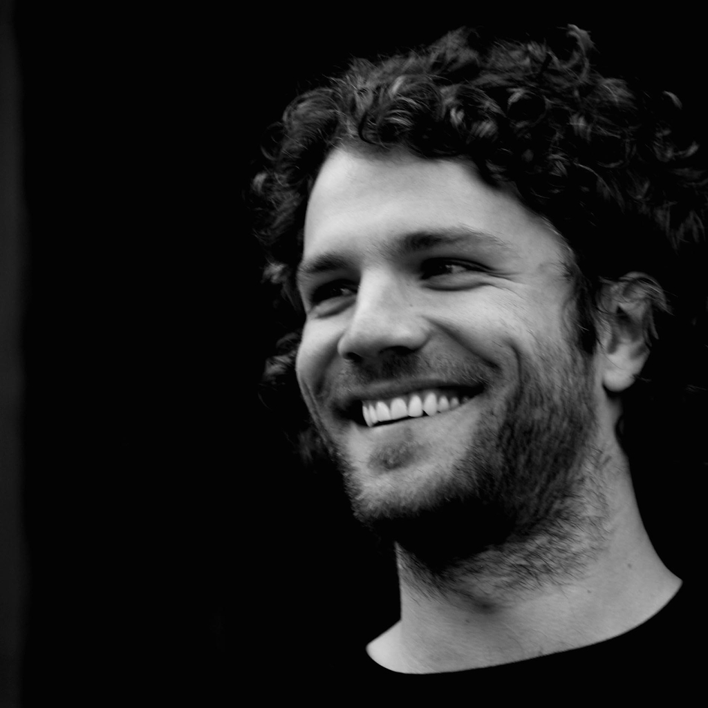 Schwarz-weiß Porträt von Benny. Er lacht herzlich.