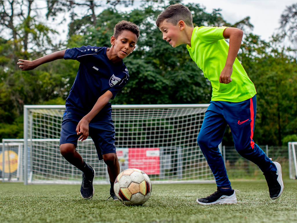 Zwei Jungs beim Fussball spielen.
