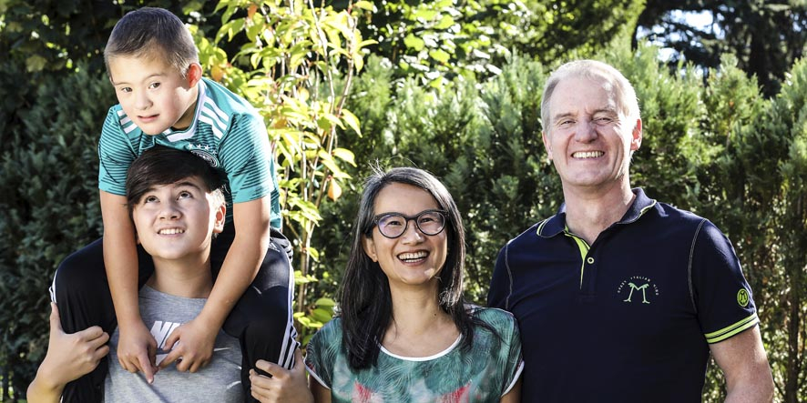 Eine Familie mit zwei Kindern, eines davon mit Downsyndrom 