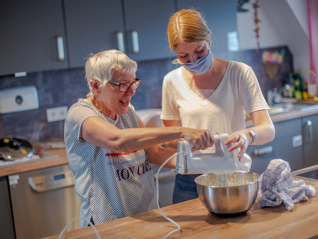 Zwei Frauen stehen in der Küche und rühren Teig.