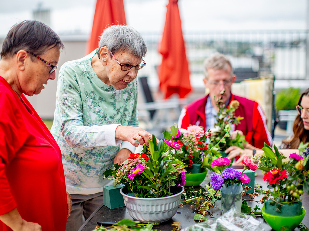 Zwei Frauen bepflanzen Blumenkübel.