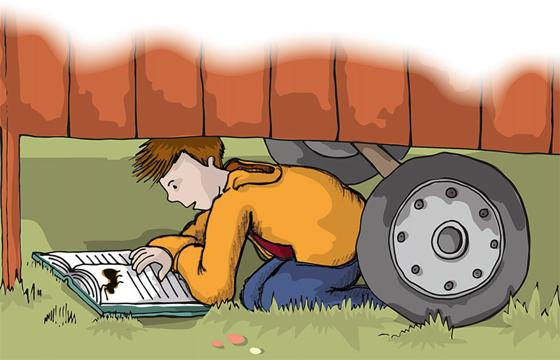 Tom sitzt unter dem Bauwagen und liest ein Buch über Ameisen.