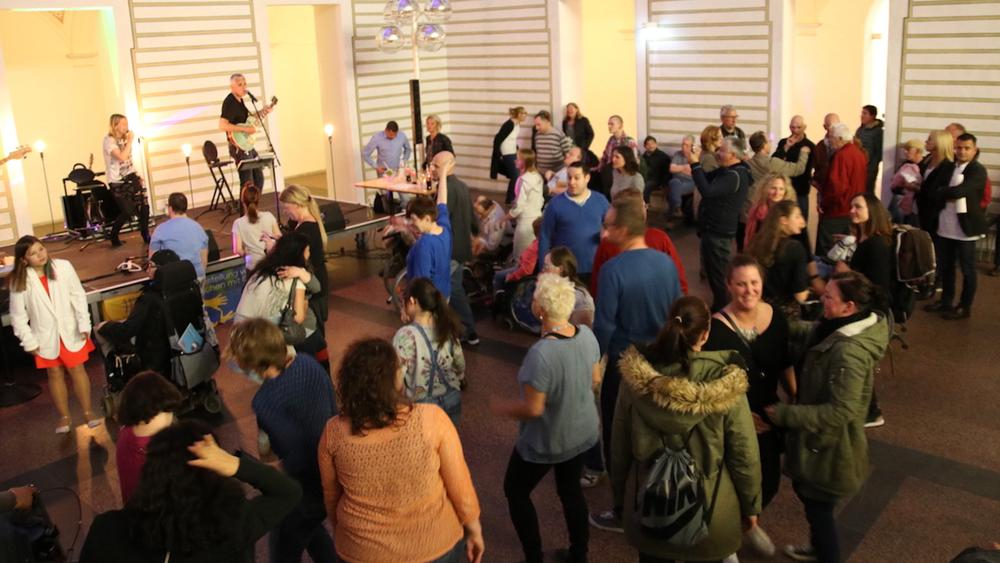 viele menschen tanzen zusammen in einem saal