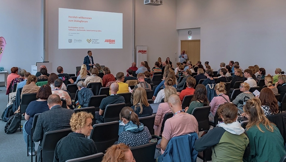 Eine Person hält einen Vortrag vor etwa 70 Menschen