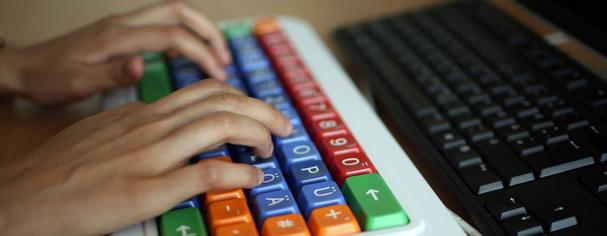 Hände an einer Spezial-Tastatur. 