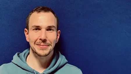 Fabio Priano, ein junger Mann mit kurzen braunen Haaren und Drietagebart.