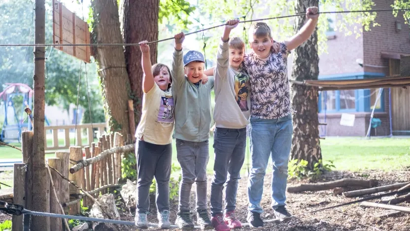 Vier Kinder balancieren auf einem Drahtseil