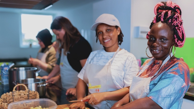 Zwei Frauen schneiden Kartoffeln in kleine Würfel.