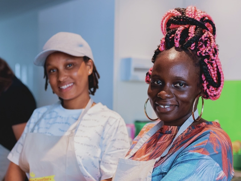 Zwei Frauen schneiden Kartoffeln in kleine Würfel.