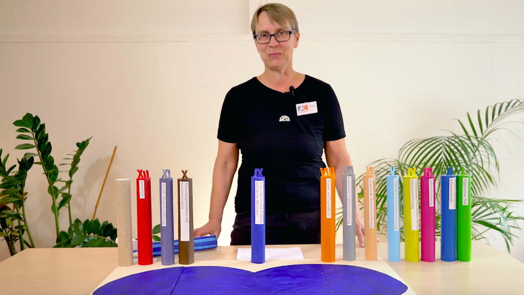 Eine Frau mit Brillen und kurzen Haaren steht vor einem Schreibtisch