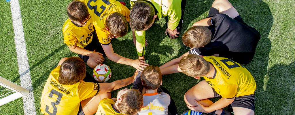 Die Spieler des Fußballvereins Teutonia Überruhr legen ihre Hände im Kreis übereinander