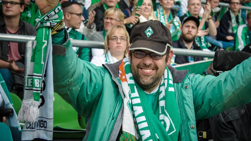 Ein Fan des SV Werder Bremen jubelt bei einem Bundesligaspiel im Stadion.