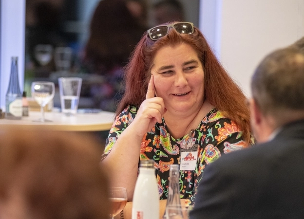 Annette Kob spricht mit einem anderen Gast auf einer Veranstaltung