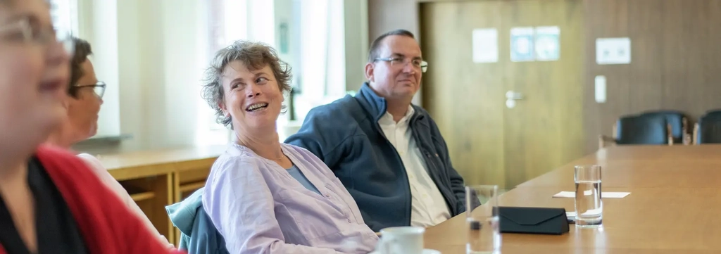 Mehrere Menschen sitzen im Ratssaal von Schneverdingen und unterhalten sich.