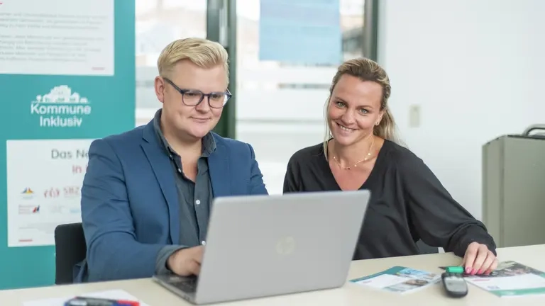 Ein Mann und eine Frau arbeiten gemeinsam am Laptop.