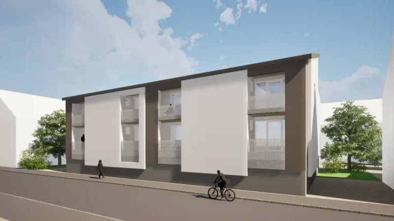 Das Bild zeigt das Modell eines an einer Straße gelegenen zweistöckigen Hauses. Es sind acht Wohungen zu sehen. Alle haben einen kleinen Balkon.