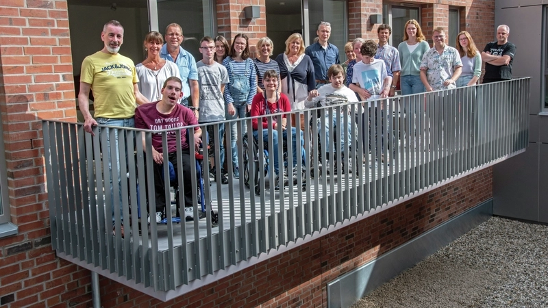 Eine Gruppe von Menschen mit und ohne Behinderung auf einem Balkon