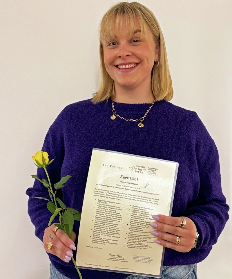 Porträt einer blonden jungen Fau, die eine Rose und ein Zertifikat hält