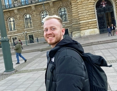 Porträt eines jungen Mannes vor einem historischen Gebäude