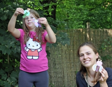 Ein Mädchen und eine junge Frau halten Selbstgebasteltes in der Hand