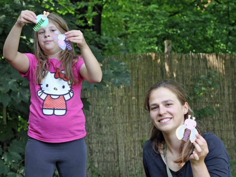Ein Mädchen und eine junge Frau halten Selbstgebasteltes in der Hand