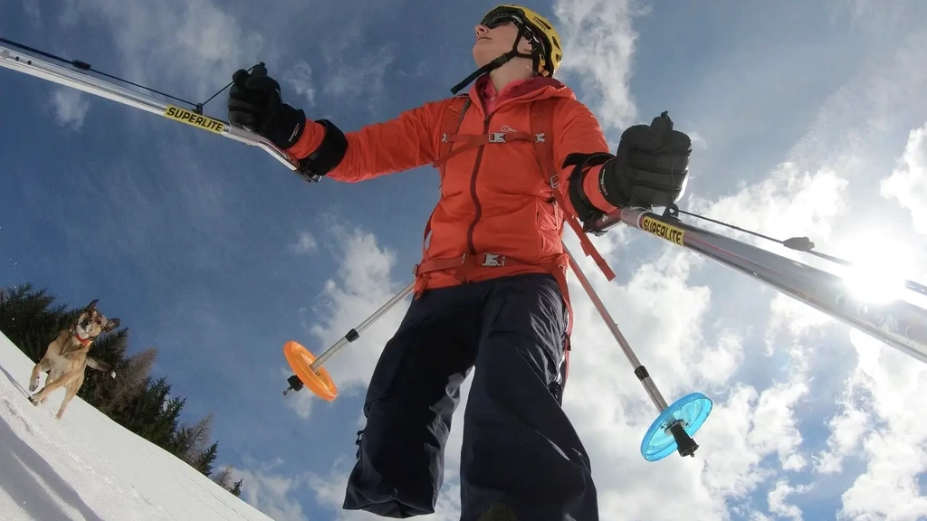 Eine einbeinige Frau auf Skiern mit Hund in einer Schneelandschaft 