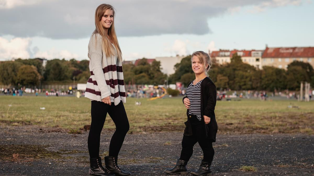 Nicole und Jacqueline stehen sich gegenüber und lächeln in die Kamera.