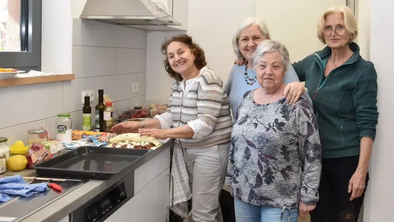 Vier Frauen stehen in der Küche und bereiten das Essen vor