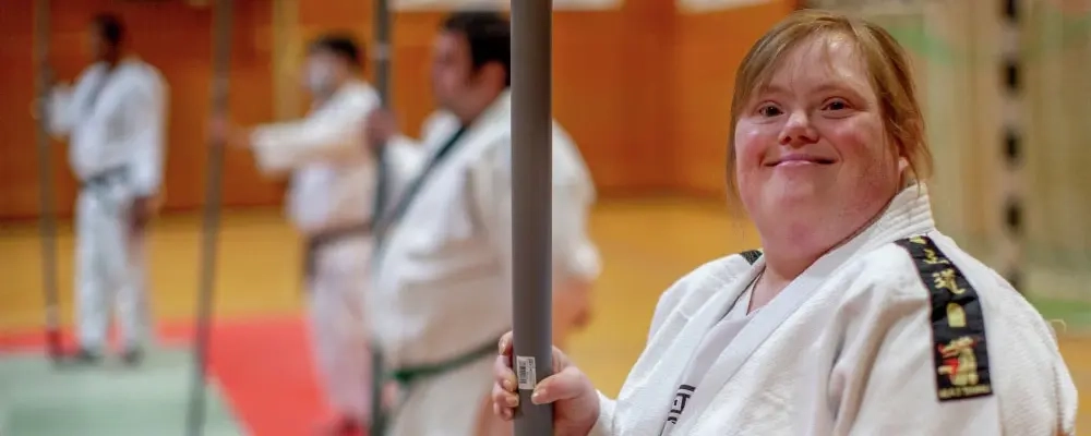 Eine junge Frau mit Downsyndrom steht in einer Halle beim Kapfsport-Training