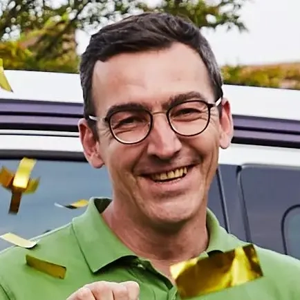 Eine Familie steht im goldenen Konfettiregen. Die Mutter und beiden Töchter recken jubelnd die Arme in die Luft, der Vater hält ein Glückslos in der Hand.