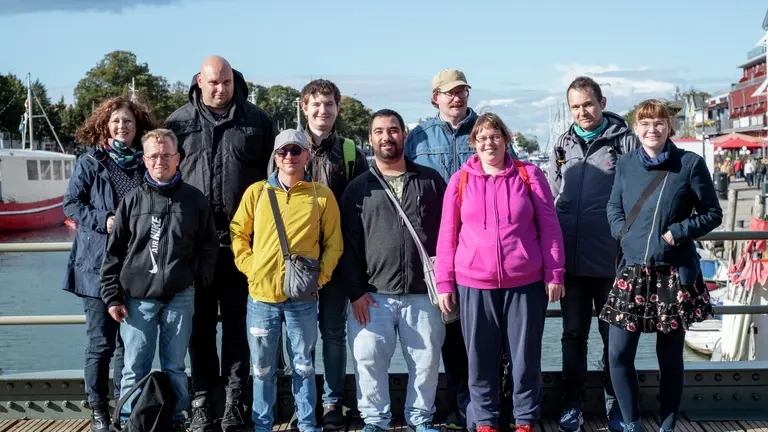 Eine Gruppe von Menschen sehen in die Kamera.