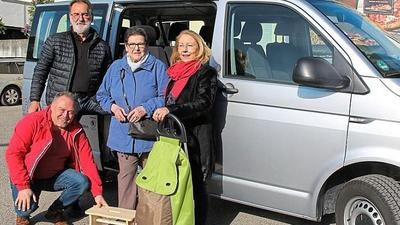 Männer und Frauen stehen vor einem Seniorenbustaxi