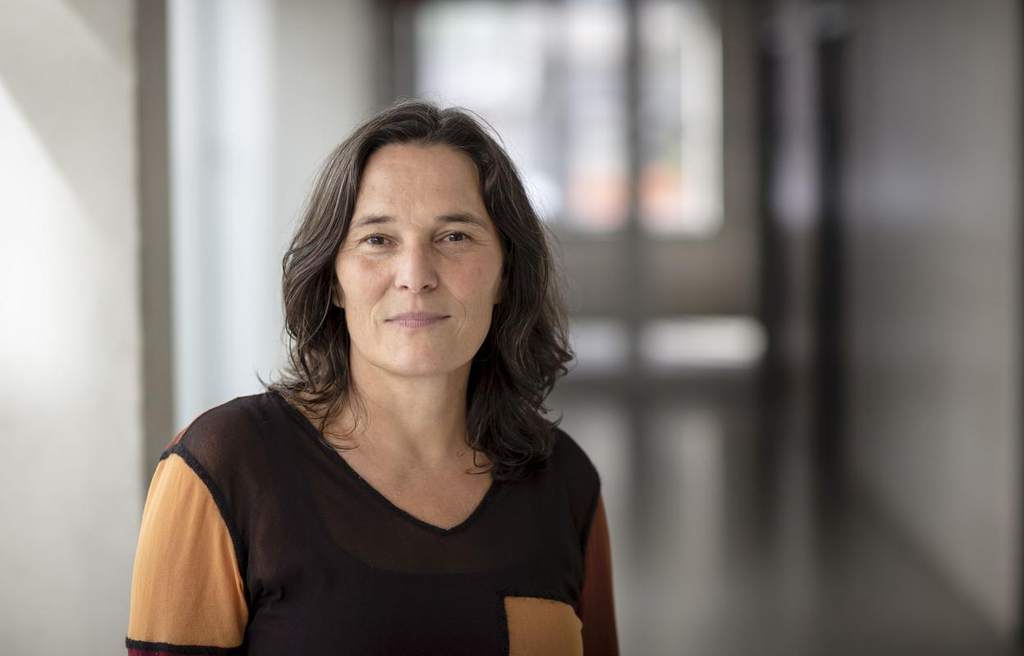 Sabine Maier steht im Schulflur und lächelt in die Kamera.