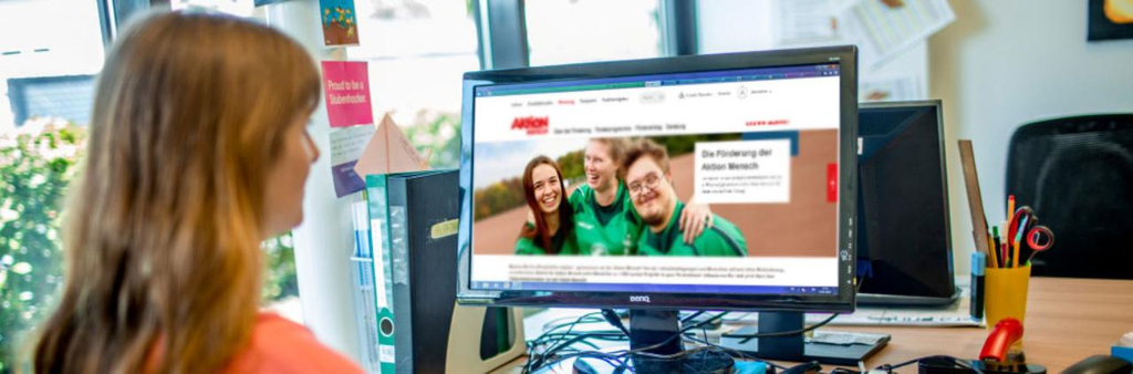 Eine Frau arbeitet an einem Computer, auf dem die Seiten der Förderung aufgerufen sind.