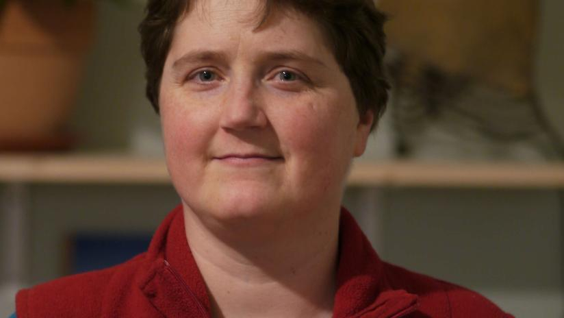 Cécile Lecomte trägt eine rote Weste und schaut in die Kamera.