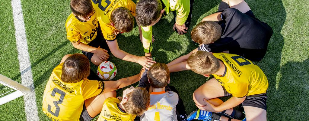 Die Spieler des Fußballvereins Teutonia Überruhr legen ihre Hände im Kreis übereinander