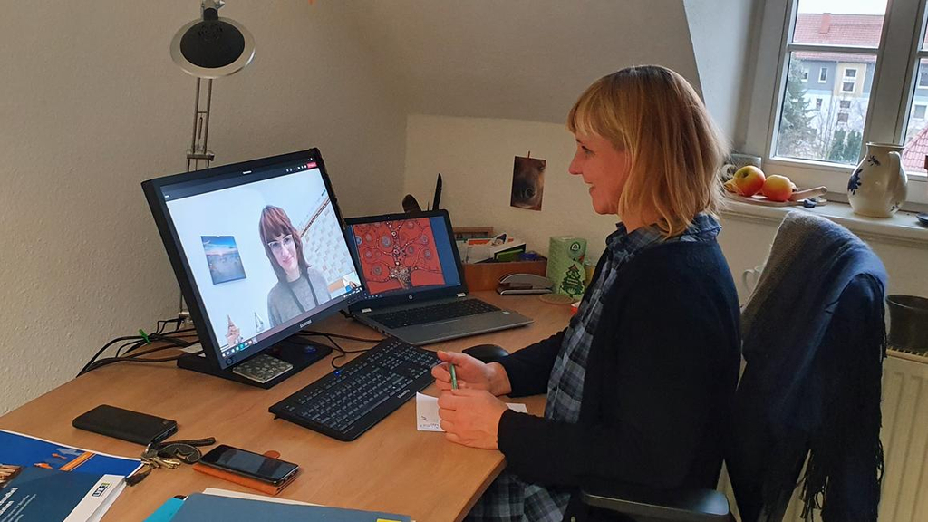 Eine Frau unterhält sich per Videokonferenz am PC mit einer anderen Frau